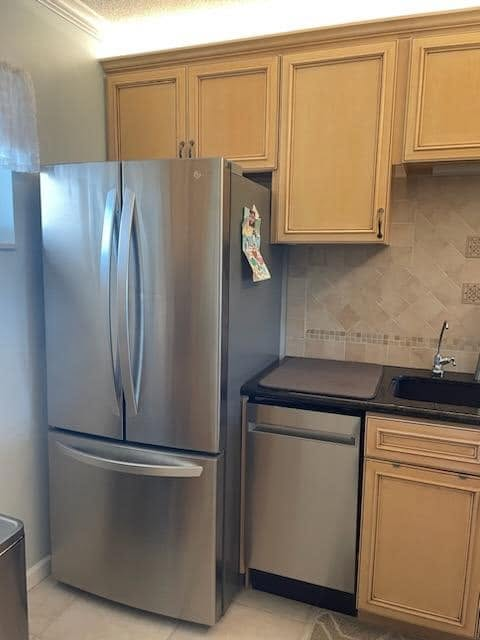 Kitchen detail with tan cabinetry and stainless appliances