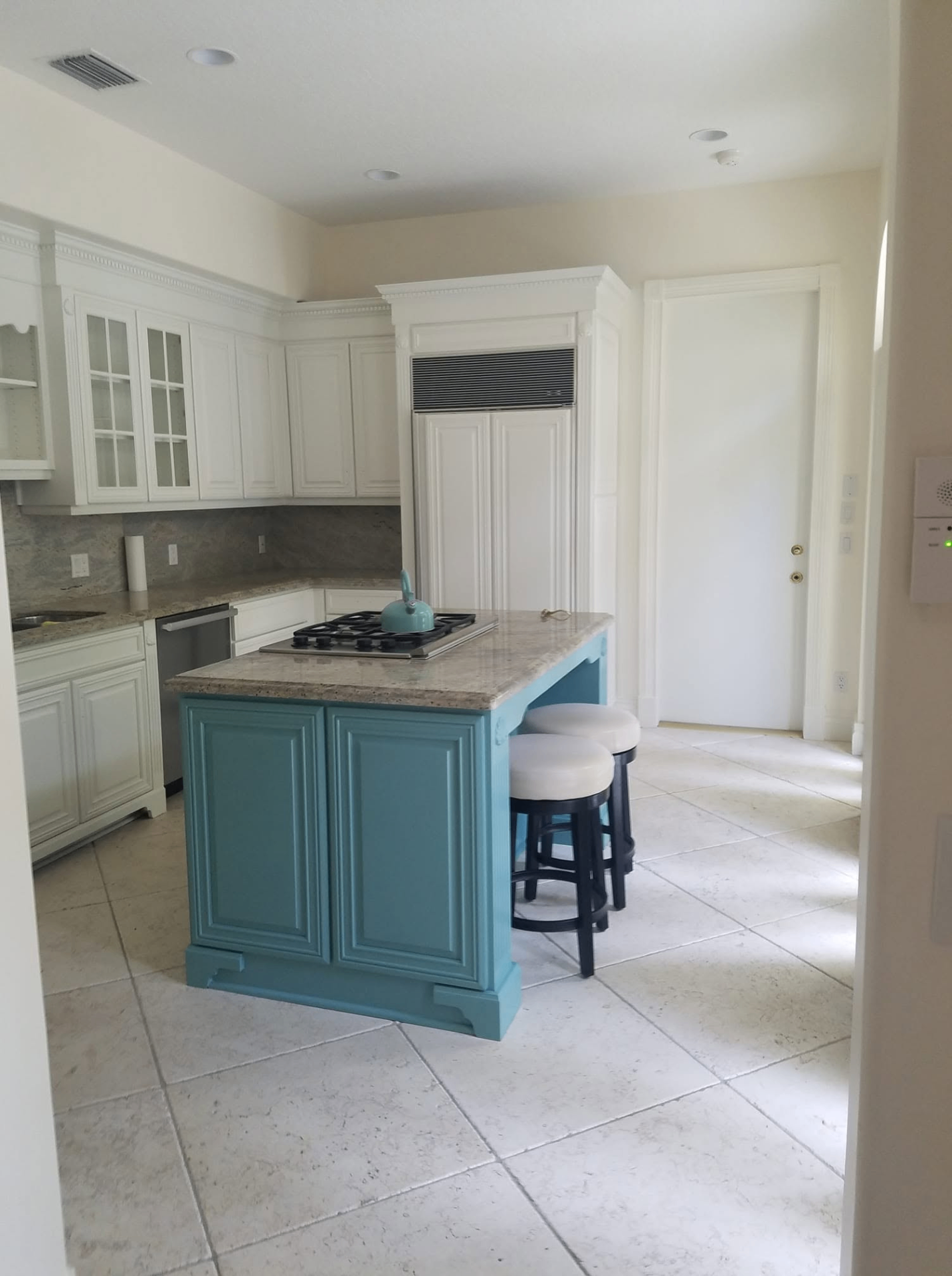 Bright white kitchen with a custom teal-painted island