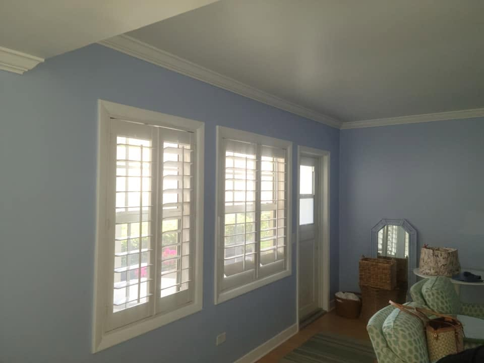 Sunroom with soft blue walls and white plantation shutters
